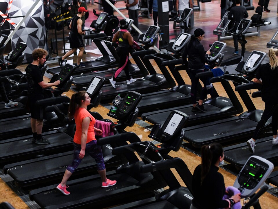 Des personnes courent sur des tapis à l'intérieur d'un gym en Allemagne.