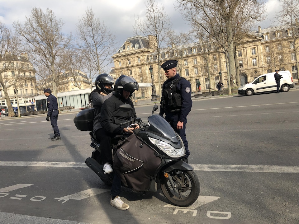 Un agent parle demande ses papiers à un motocycliste.