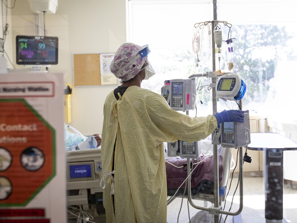 Une infirmière s'occupe d'un patient aux soins intensifs en Ontario.