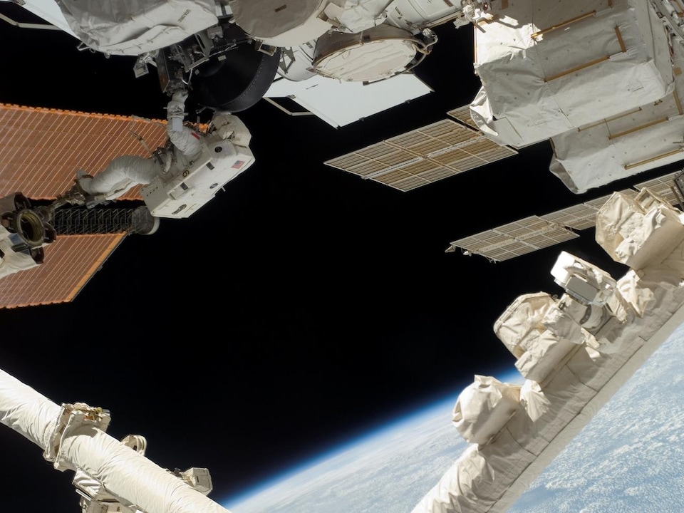 Installé à l'extrémité du Canadarm2, l'astronaute canadien Dave Williams participe à la deuxième sortie spatiale de la mission STS-118, pour remplacer un gyroscope défectueux.