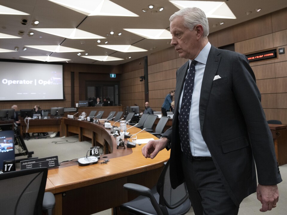 Dominic Barton marche dans la pièce où siège le comité parlementaire devant lequel il doit témoigner.