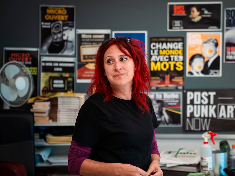 Marie-Dominique Billequey devant un tableau en classe avec plusieurs affiches sur la littérature.
