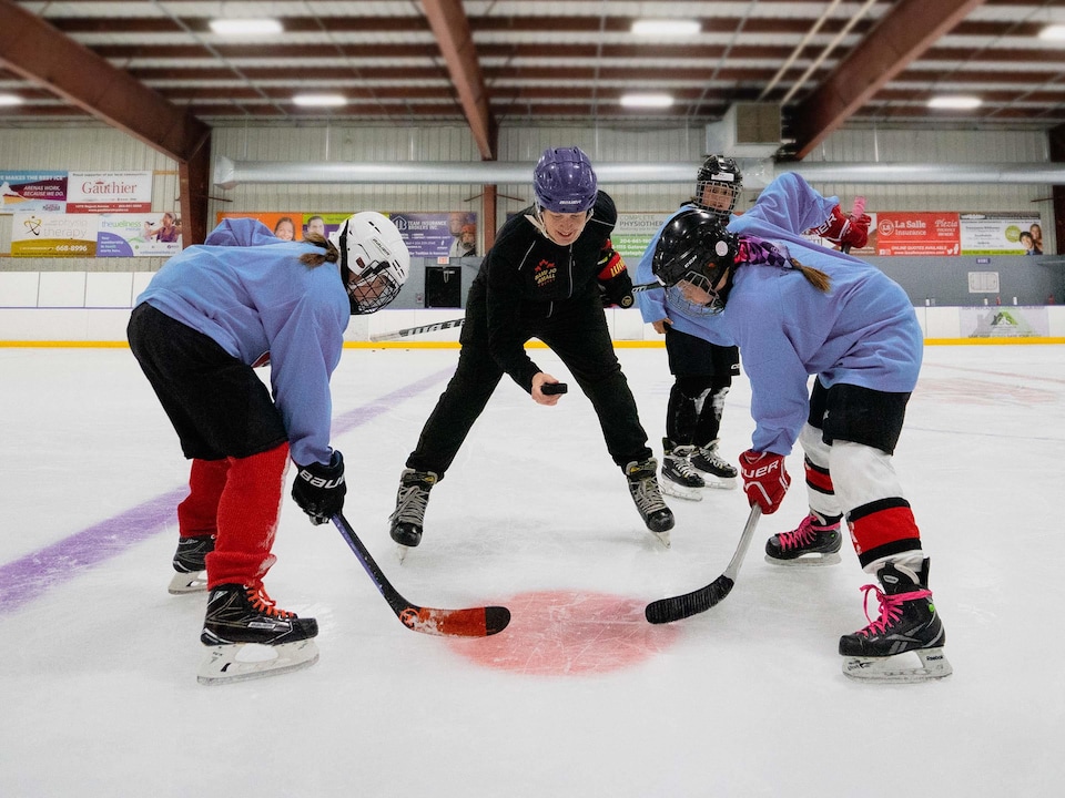 Des joueuses de hockey sur une patinoire.