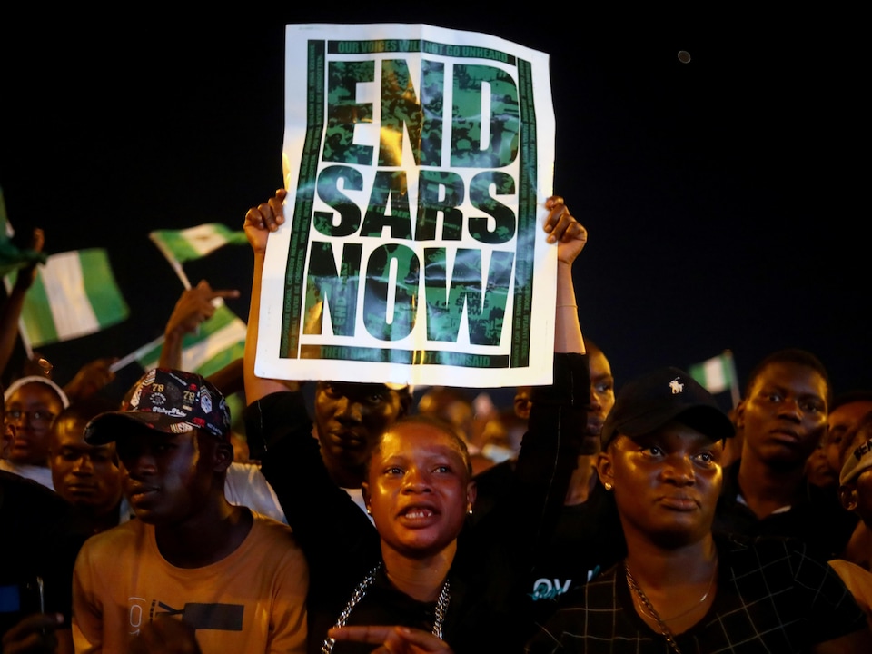 Des manifestants tiennent une pancarte sur laquelle est écrit «Mettons fin à la SARS maintenant», lors d'un rassemblement à Lagos, au Nigeria, le 17 octobre 2020.
