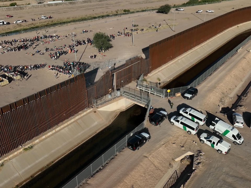 Migrants line up at the US-Mexico border.