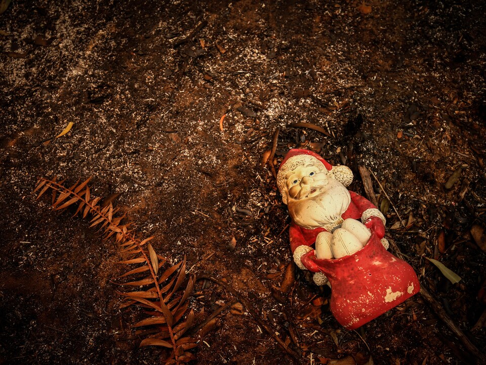 Une décoration de père Noël sur le sol brûlé.