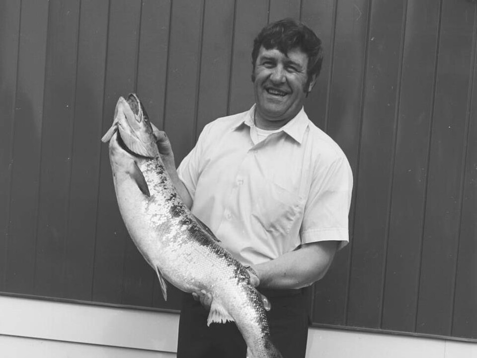 The man holding the fish smiled at the camera.