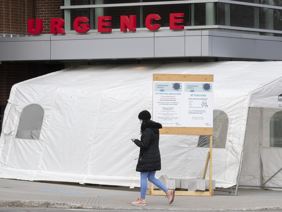 Une femme marche devant l'entrée de l’urgence de l'hôpital Jean-Talon à Montréal.