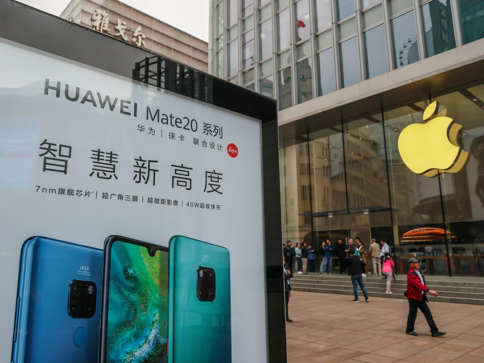 Un panneau publicitaire de Huawei est visible devant un magasin Apple dans une rue de Shanghai.