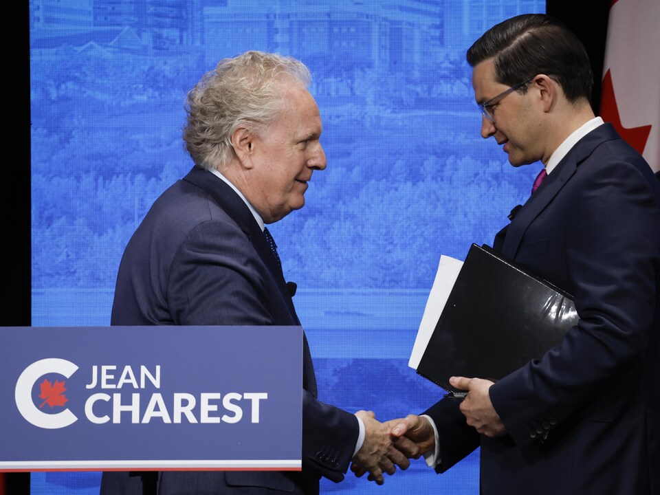 Jean Charest and Pierre Boylevre shake hands.