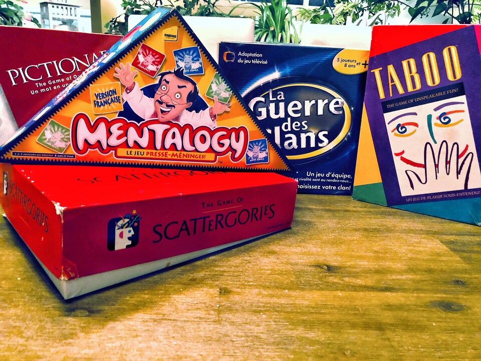 Plusieurs jeux de société sont sur une table, dont Mentalogy, La guerre des clans et Taboo.