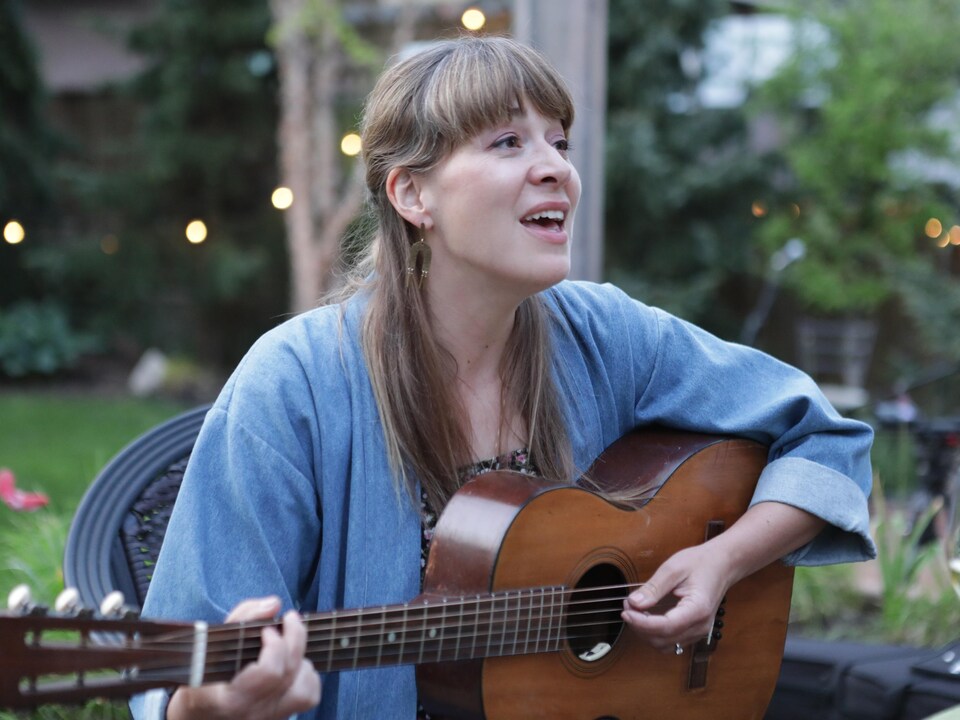 L'auteure-compositrice-interprète Jill Barber, assise à l'extérieur dans une cour, interprète une de ses chansons.