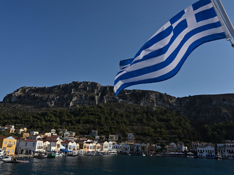 Une vue de l'île avec un drapeau de la Grèce, en avant-plan.