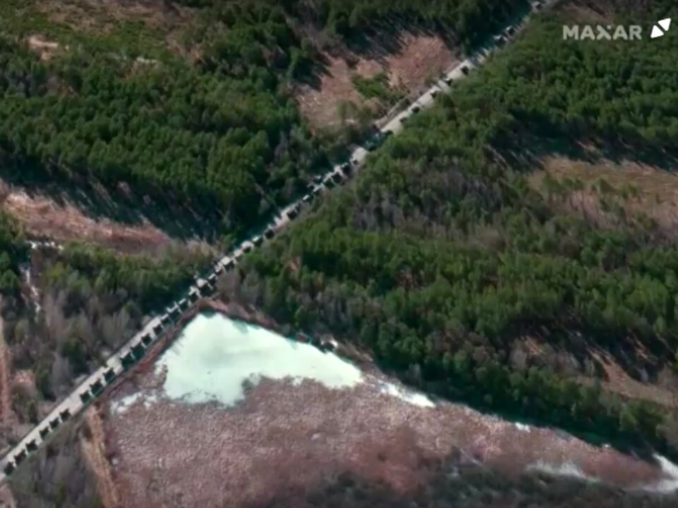 Une vue aérienne montre une route où attendent en file des chars.