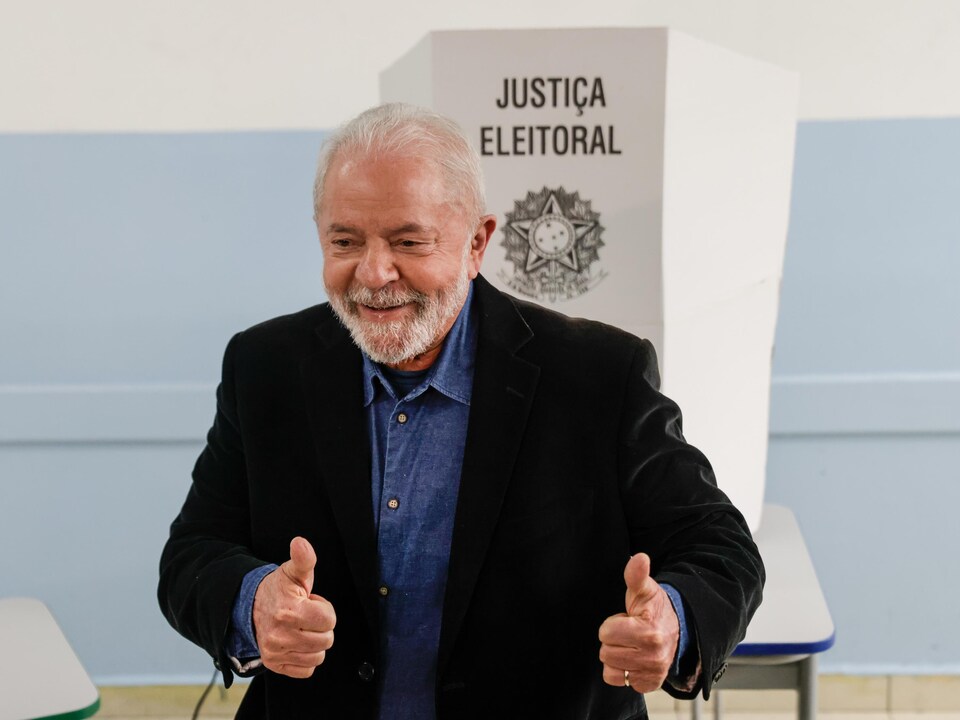 Lula, les deux pouces en l'air, pose pour les photographes après avoir voté.