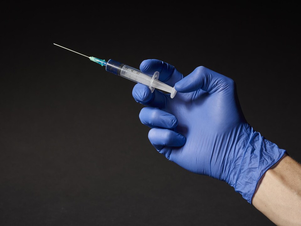 La main d'une personne avec un vaccin.