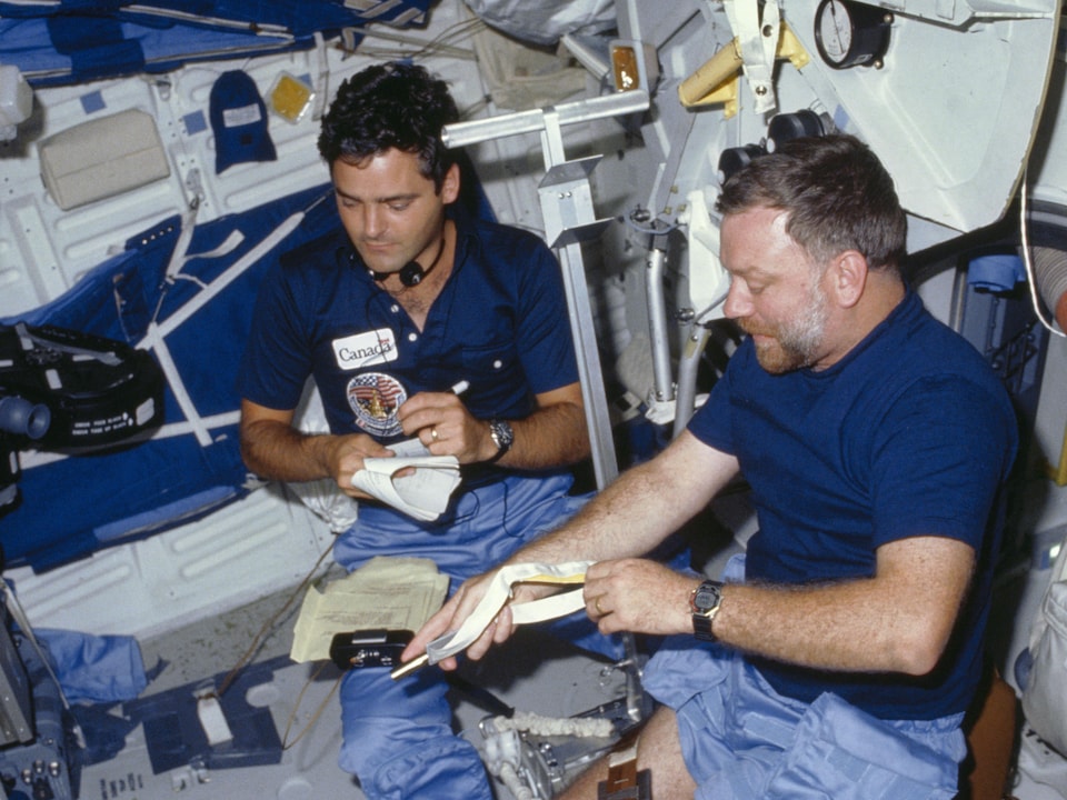 L'astronaute canadien Marc Garneau et l'Américain Paul Scully-Power mènent une série dexpériences à bord de la navette Challenger durant la mission STS-41G qui s'est déroulée du 5 au 13 octobre 1984.