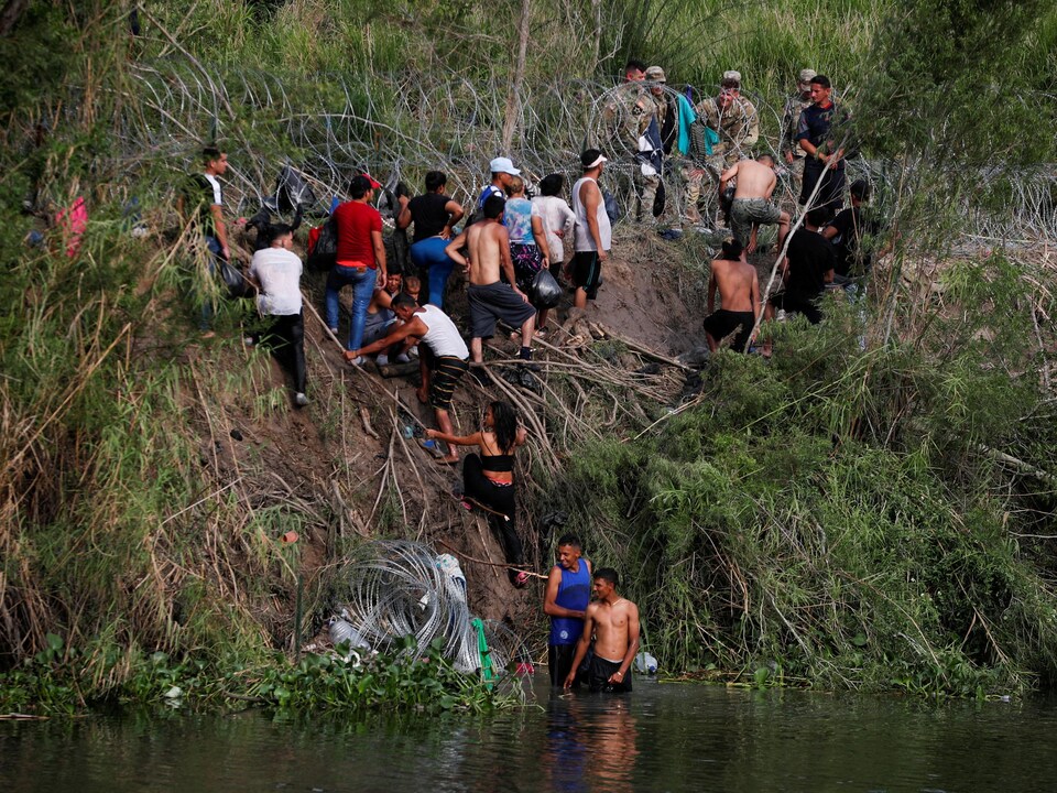 Migrants cross the Rio Bravo River in Matamoros, Mexico.