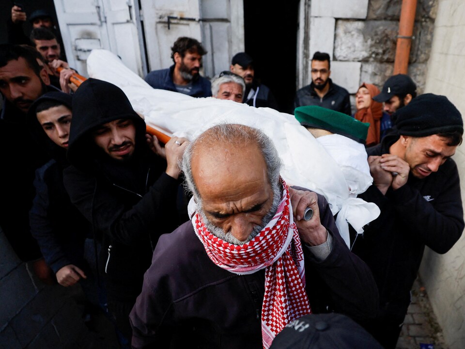 Des hommes portent le corps du Palestinien Naseem Abu Fuda lors de ses funérailles à Hébron, en Cisjordanie.