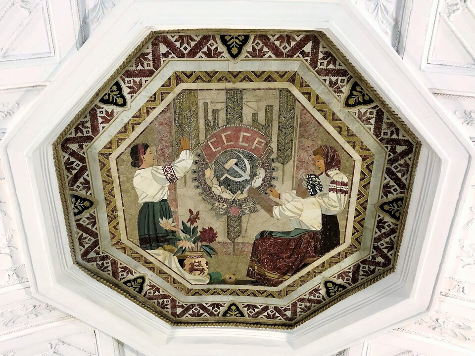 Trois fermières biélorusses et un bouquet de fleurs sur une mosaïque au plafond