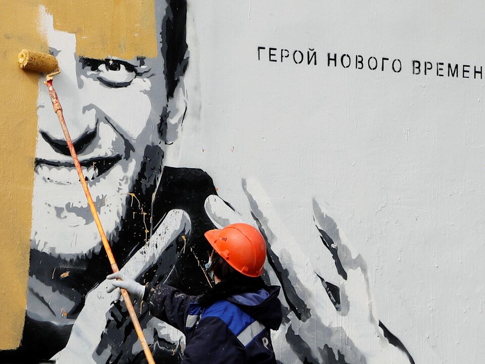 Un travailleur peint par-dessus une murale pro-Navalny en Russie.