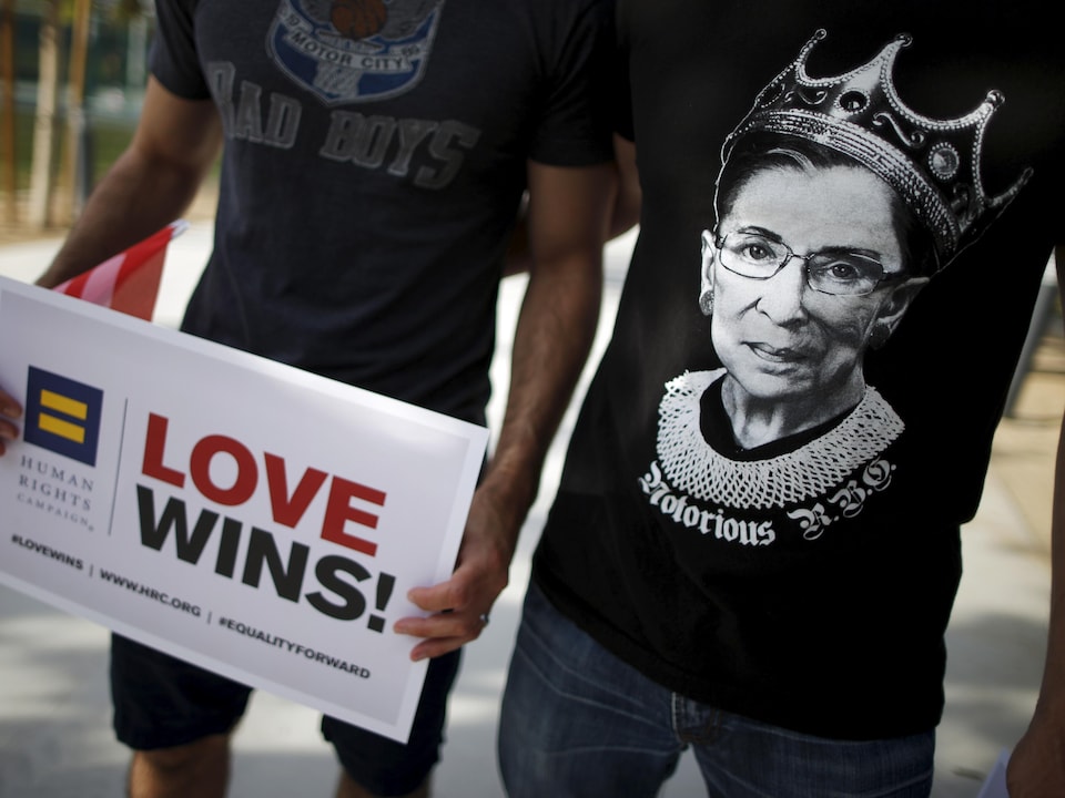 Un homme porte un t-shirt sur lequel est imprimé le visage de la juge Ruth Bader Ginsburg, avec l'inscription « Notorious RBG ».