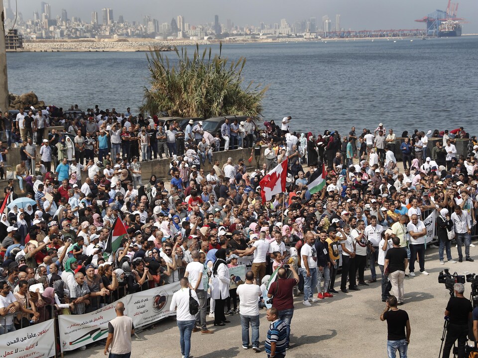 Une foule de manifestants devant les locaux de l'ambassade canadienne à Beyrouth, en face de la mer.