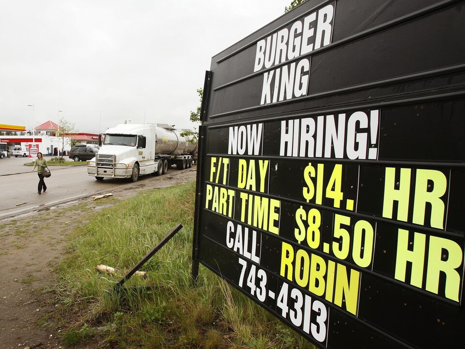Une pancarte devant le restaurant Burger King à Fort McMurray en 2006. On peut lire : «On engage. Salaire de 14 $/h.»