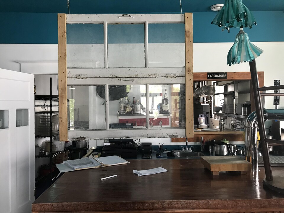 Un plexiglass fait à partir d'une vieille fenêtre est suspendu au-dessus d'un comptoir dans un restaurant.
