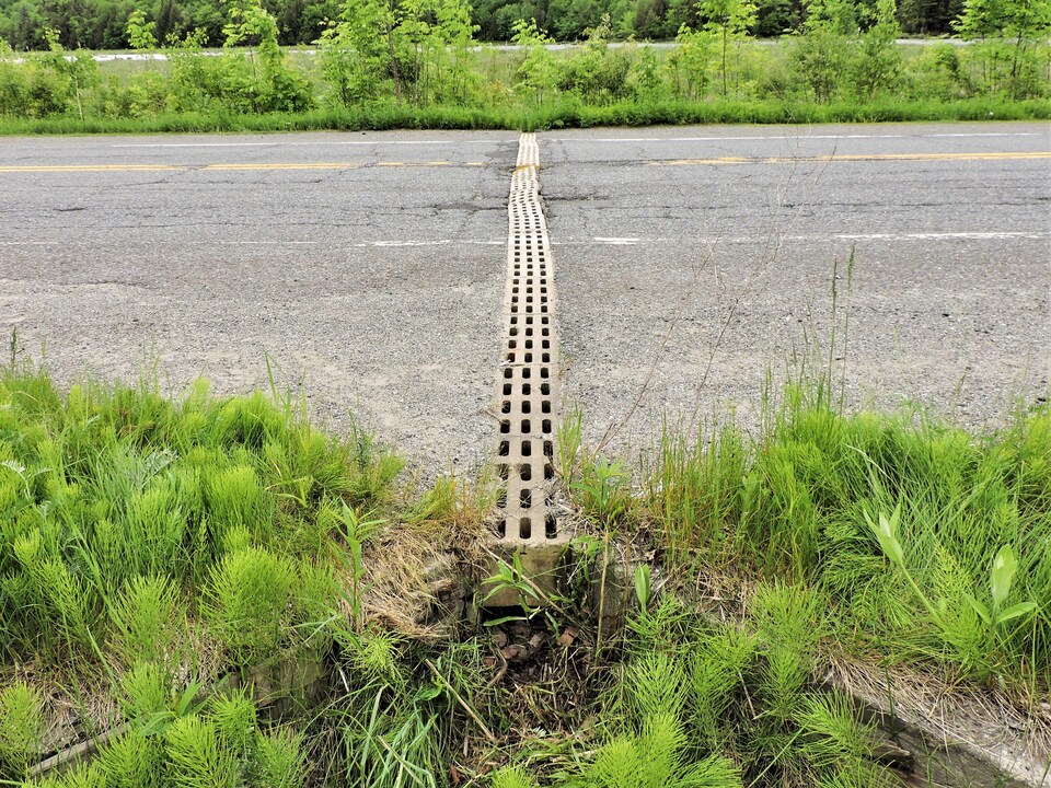 Un ponceau de béton au beau milieu de la route.