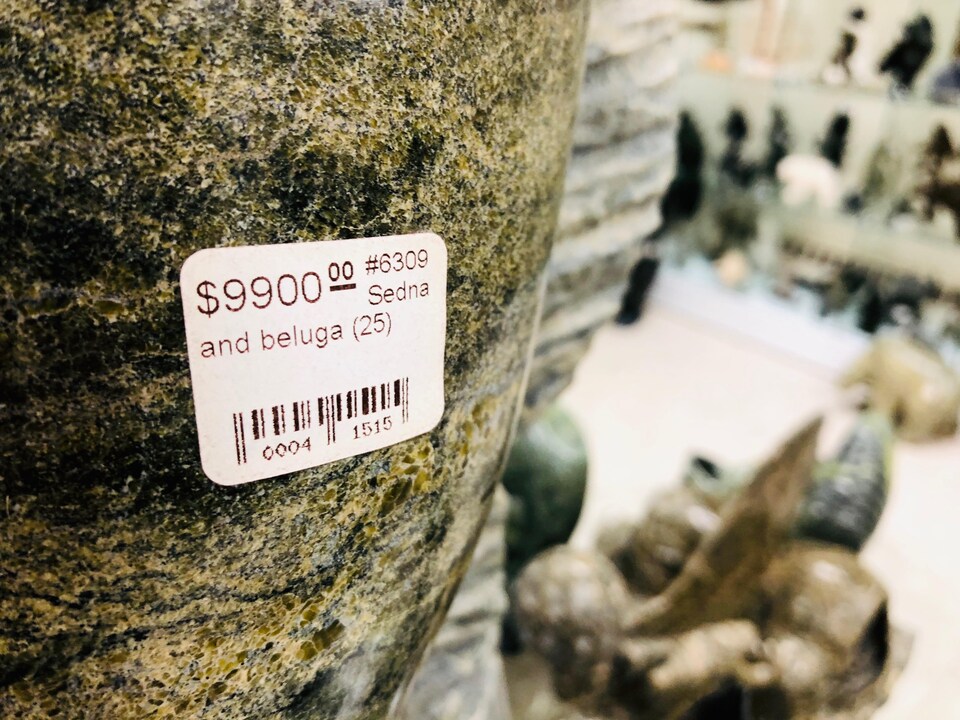 L'image d'une étiquette sur la sculpture d'une sirène et d'un béluga qui indique que l'oeuvre est à vendre pour 9900 $.