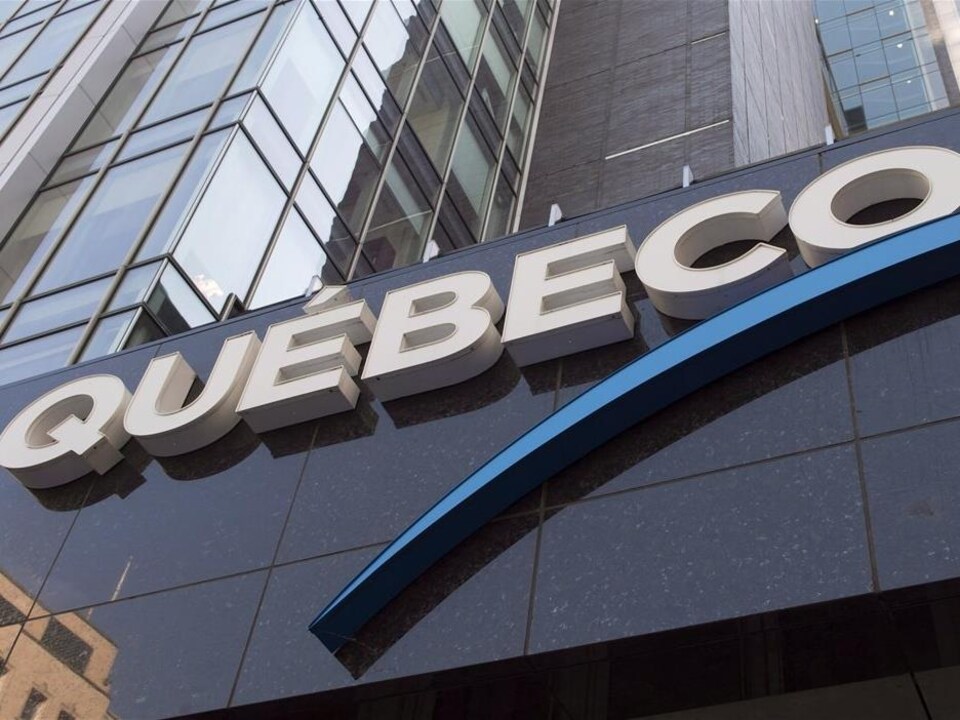 Vue rapprochée du logo de Québecor sur la façade de l'immeuble du siège social.