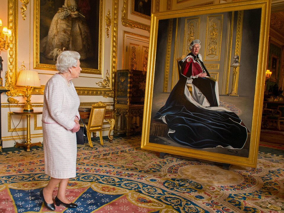 La reine Élisabeth II observe son portrait dans une grande pièce aux ornements dorés.