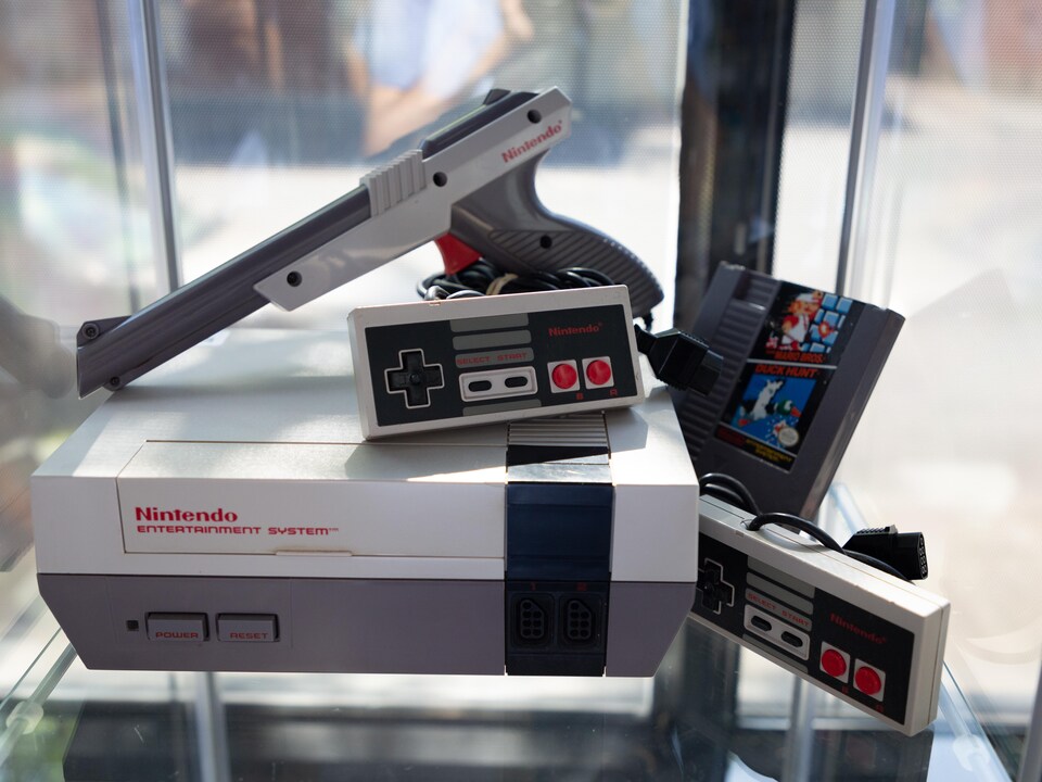 Une photo montrant une console NES avec deux manettes, un pistolet en plastique et une cartouche combinant les jeux Super Mario Bros. et Duck Hunt.