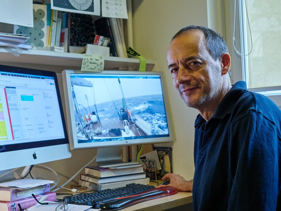 Roberto Casati, souriant, assis devant son ordinateur.              