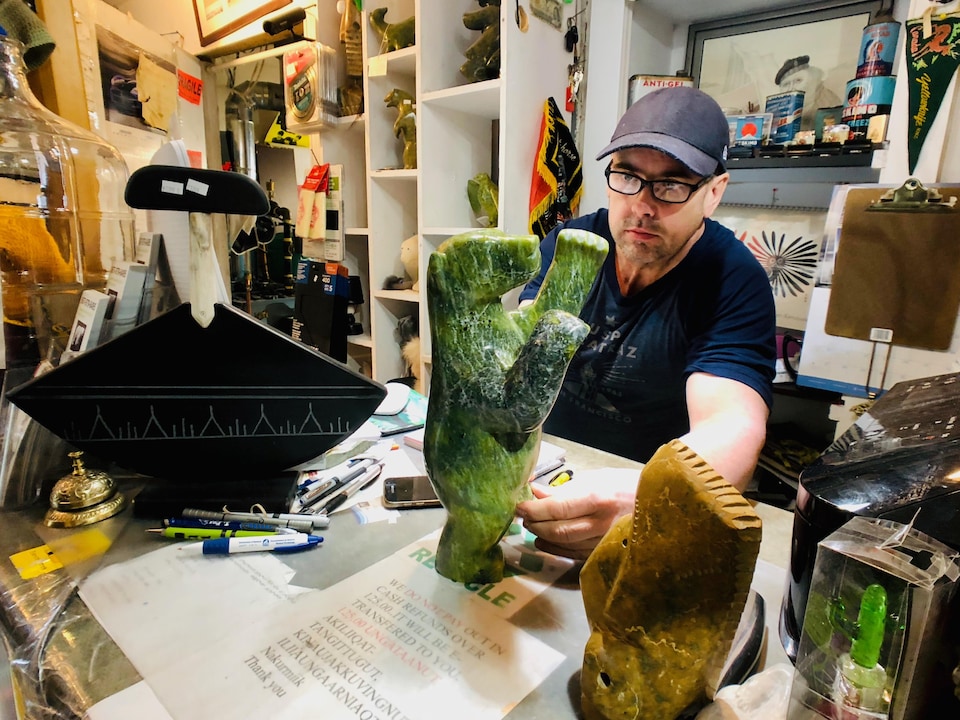 Une image montre le grossiste et distributeur Bryan W. Hellwig qui regarde de près un ours dansant dans son commerce d'Iqaluit, au Nunavut
