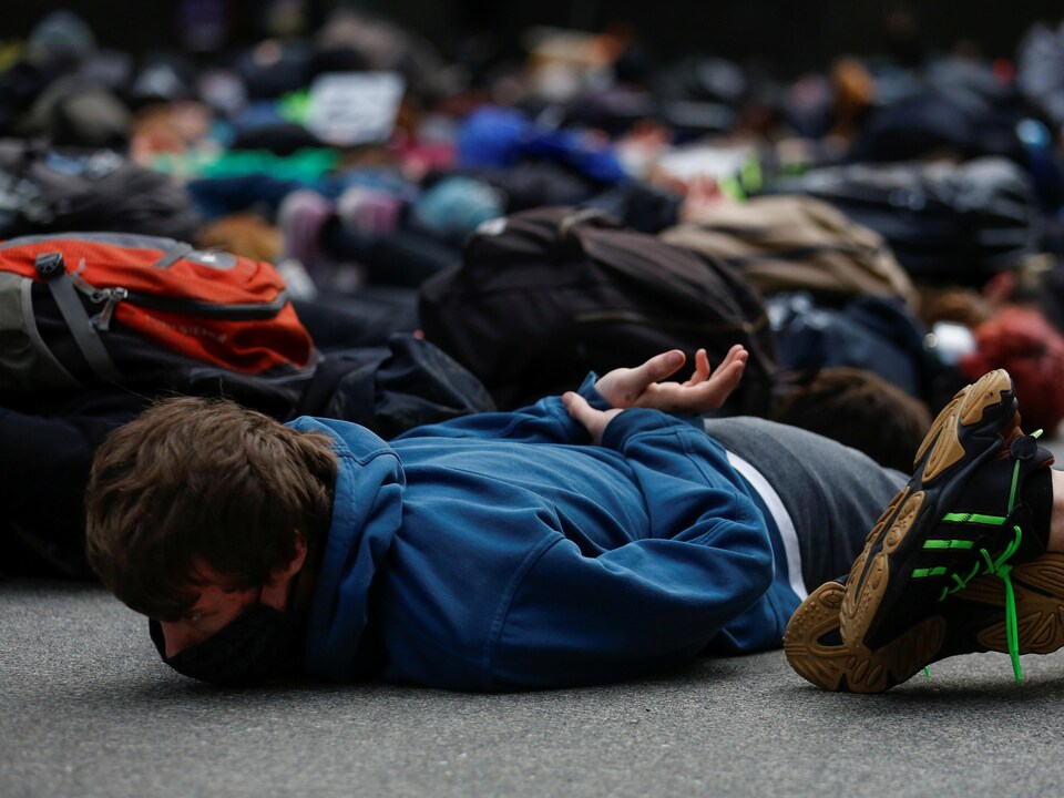 Des manifestants sont couchés au sol, les mains dans le dos.