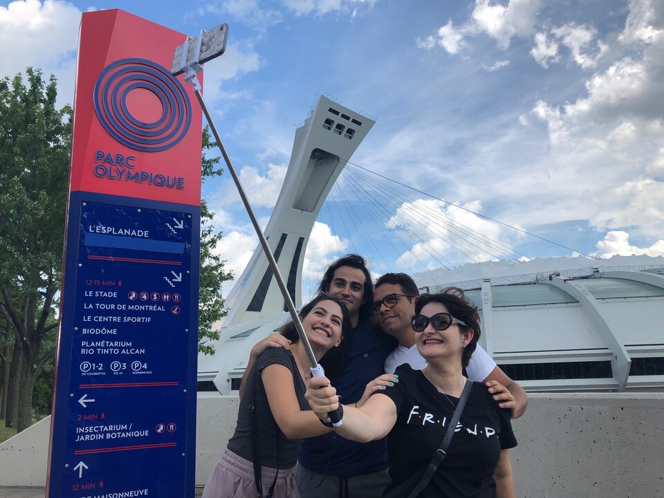Une famille de touristes brésiliens se photographie devant le stade olympique.