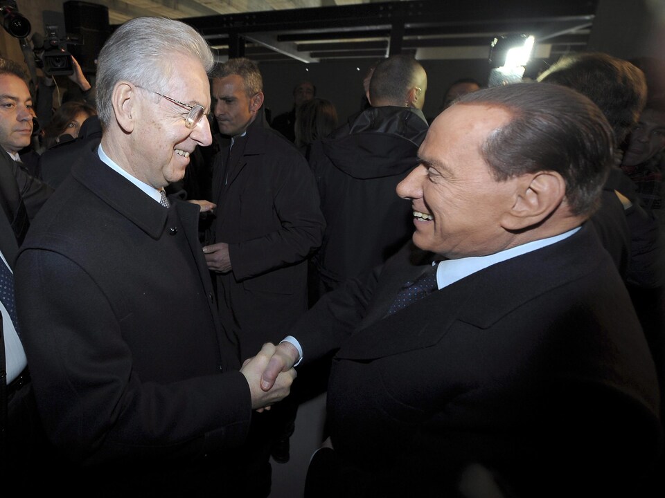 Two men shake hands.