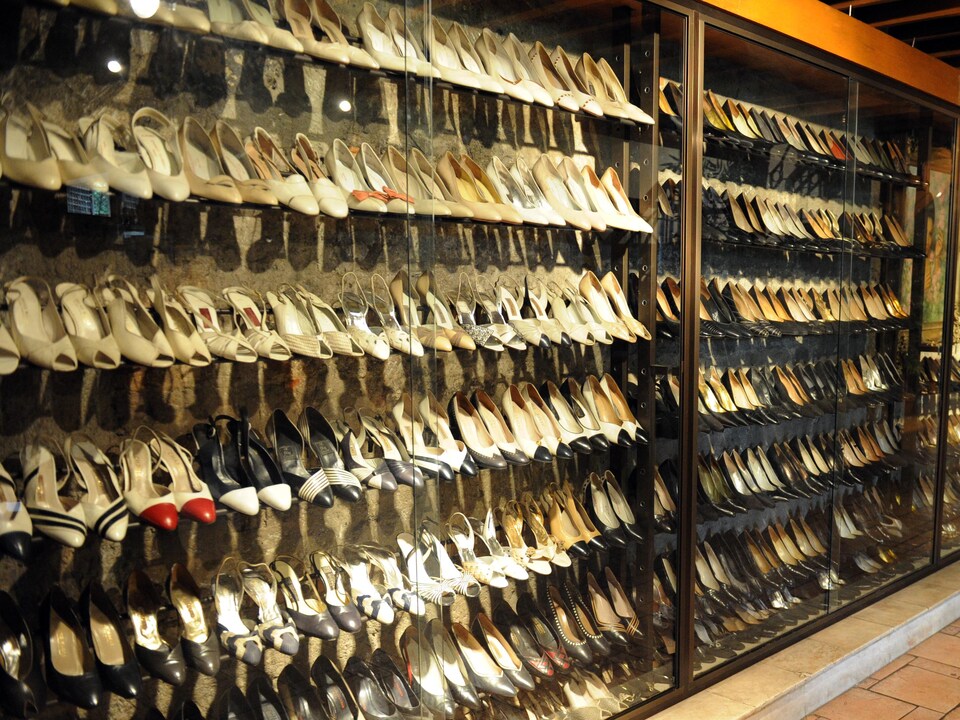 Des centaines de souliers exposés sur des présentoirs.