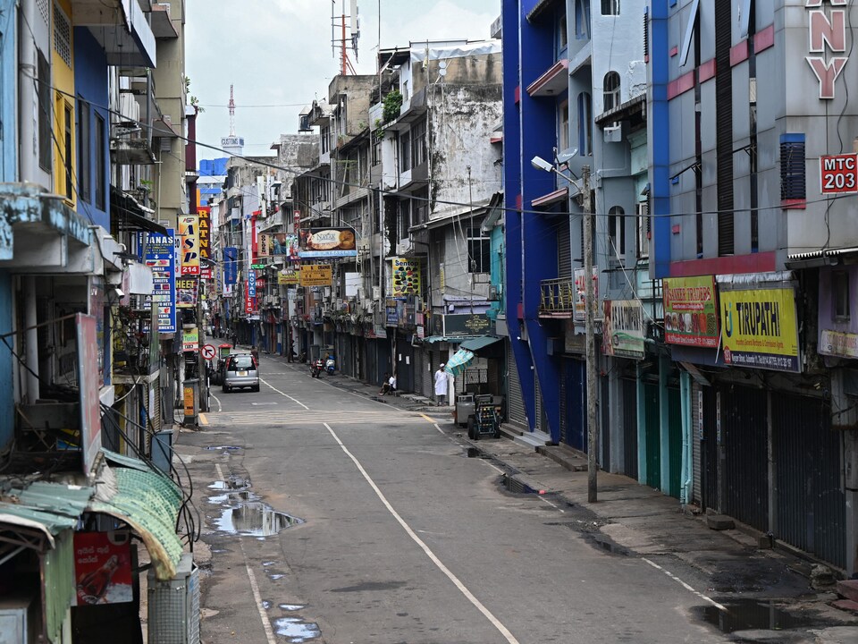 Des magasins fermés le long d'une rue déserte à Colombo.