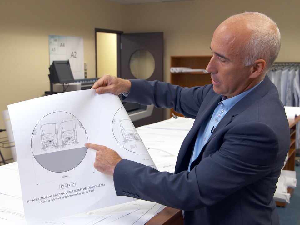 On voit M. Paquet qui montre à l'écran un plan d'un tunnel.