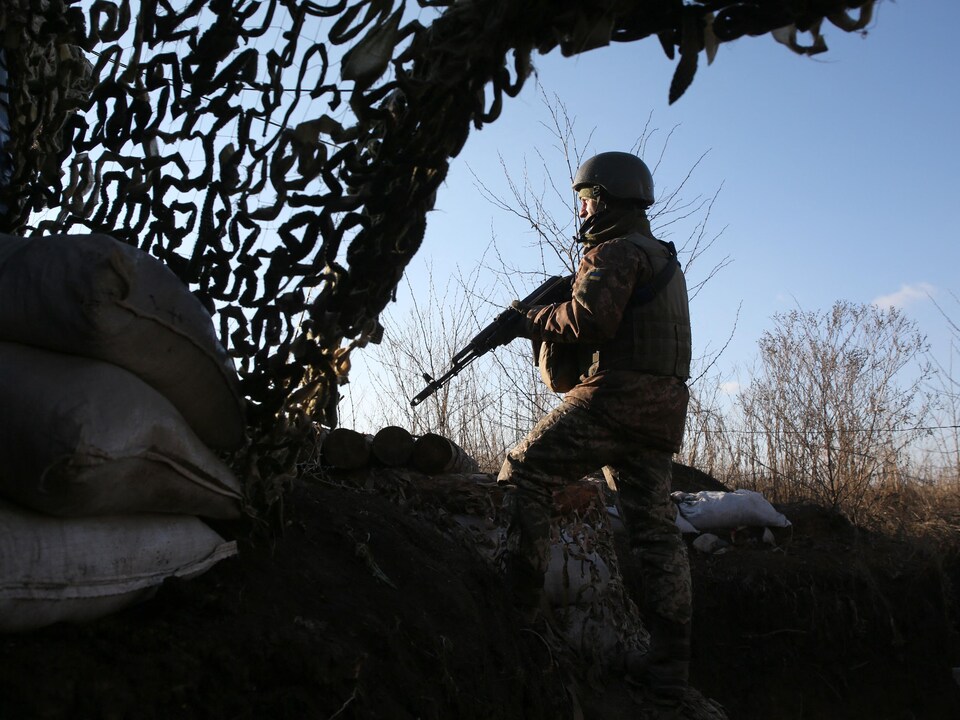 Un soldat portant une arme dans un paysage d'hiver.