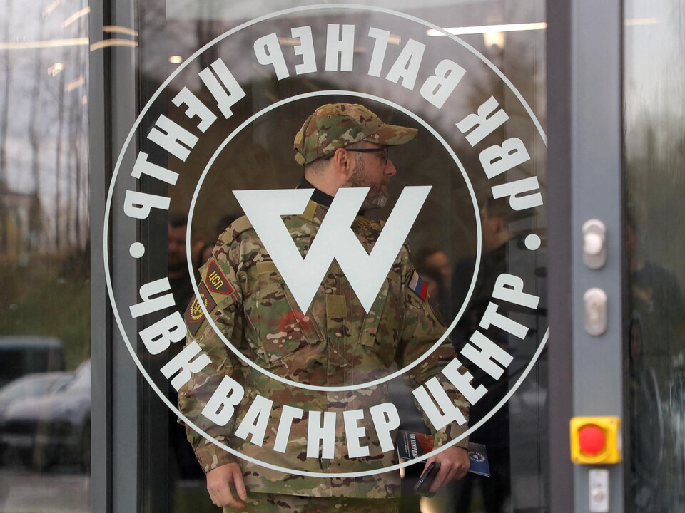 Un homme portant un uniforme de camouflage entre dans les bureaux du groupe militaire privé Wagner, à Saint-Pétersbourg.