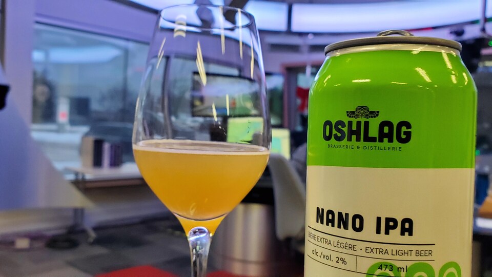 un verre de bière et sa canette côte-à-côte