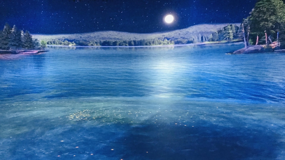 Un lac virtuel, bleu, avec des conifères autour, dans une salle d'exposition.