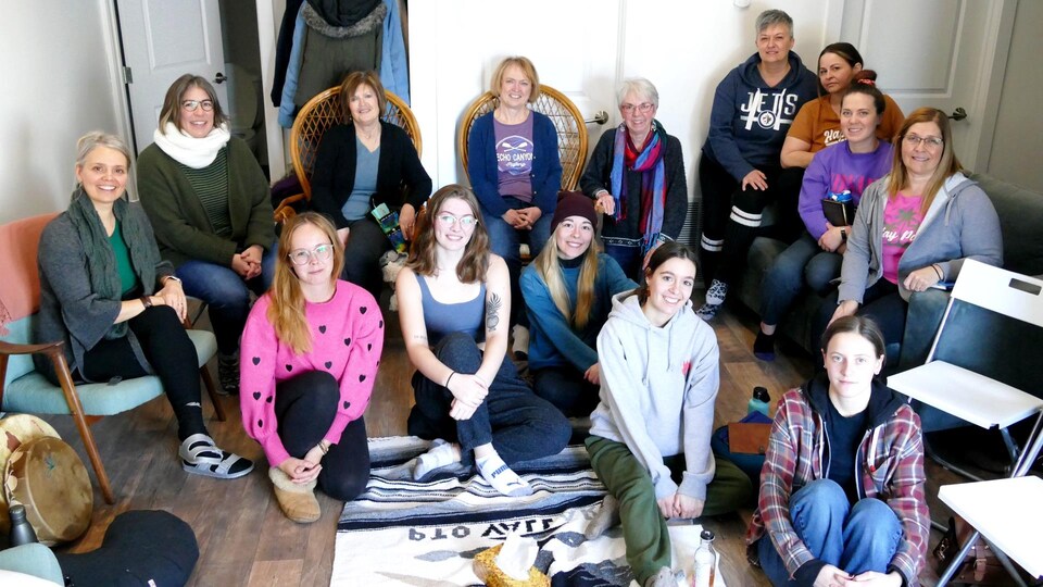 Groupe de femmes assises au sol. 