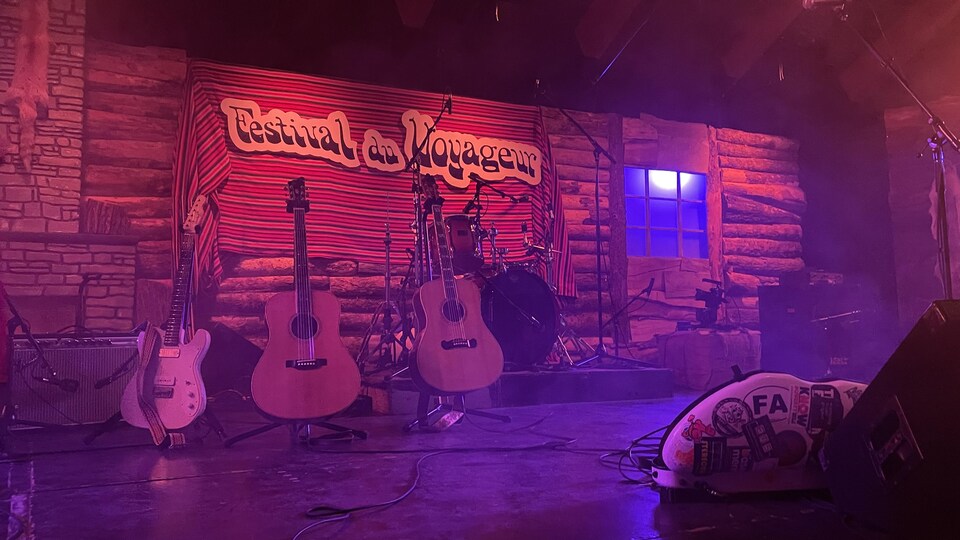 Trois guitares posées sur une scène. 