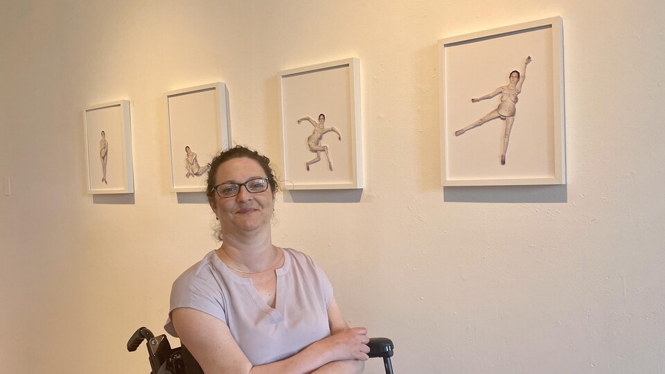 Femme en fauteuil roulant devant une série de tableaux présentant des personnages articulés. 