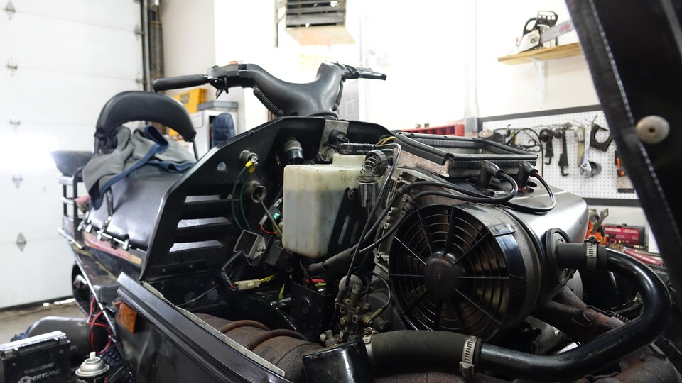 Le moteur d'un skidoo lors de sa maintenance dans un atelier mécanique. 